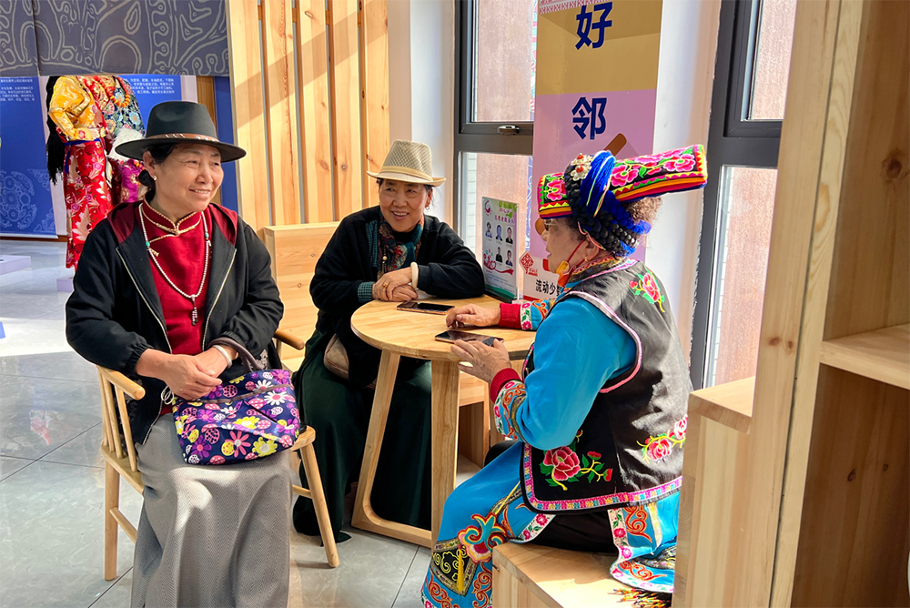 社区多民族治安巡逻队队长赵兰珍（右一）和负责民族语言翻译的“同心译”志愿者服务队的志愿者交流。人民网记者 李昊洋摄