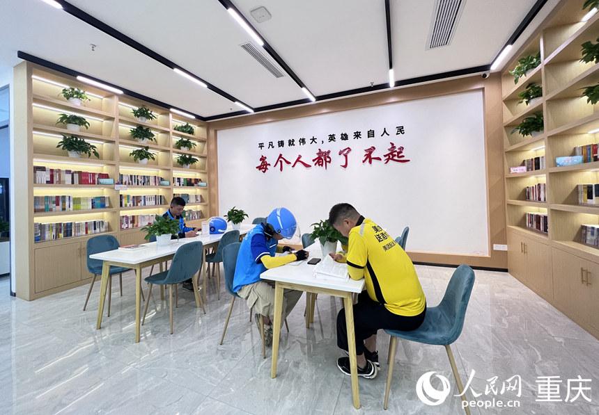 外卖小哥休单的时候在巴南区新就业群体党群服务中心学习。  人民网 胡虹摄