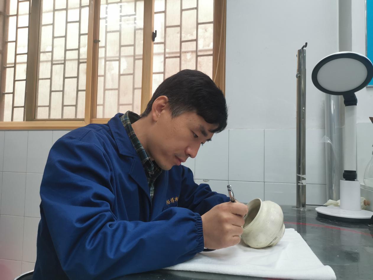  李小波正在修复一件瓷器。(王莉莉　摄)