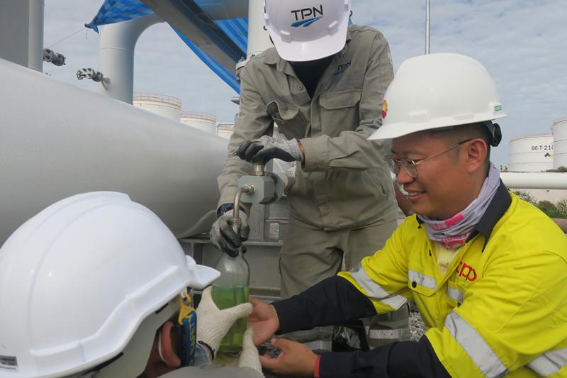 技术人员提取管道输送的成品油进行质量检测。帕拉米摄