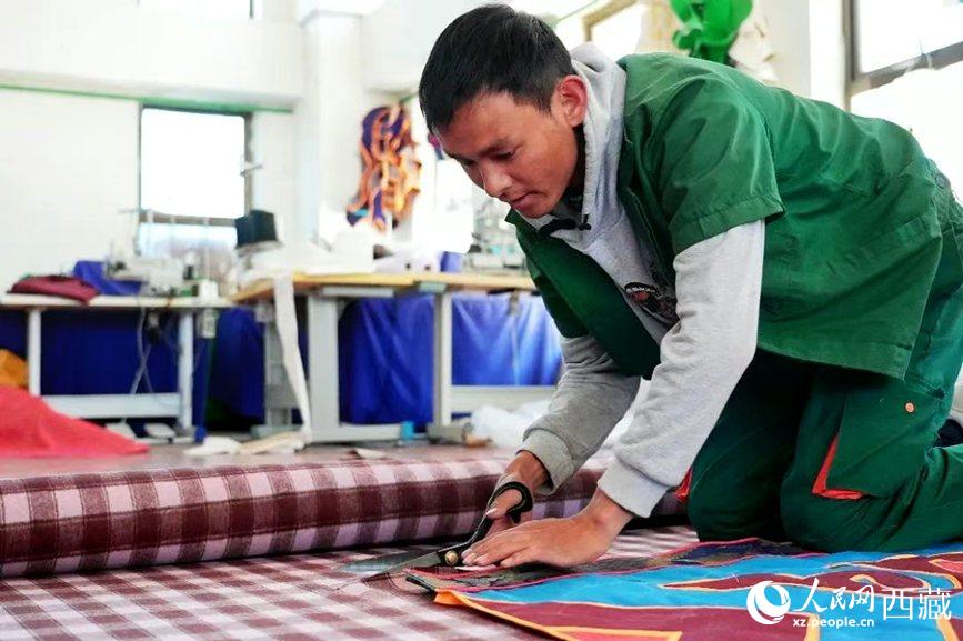 扎囊县残疾人就业创业基地员工顿珠次仁在制作藏式门帘。次仁龙布摄