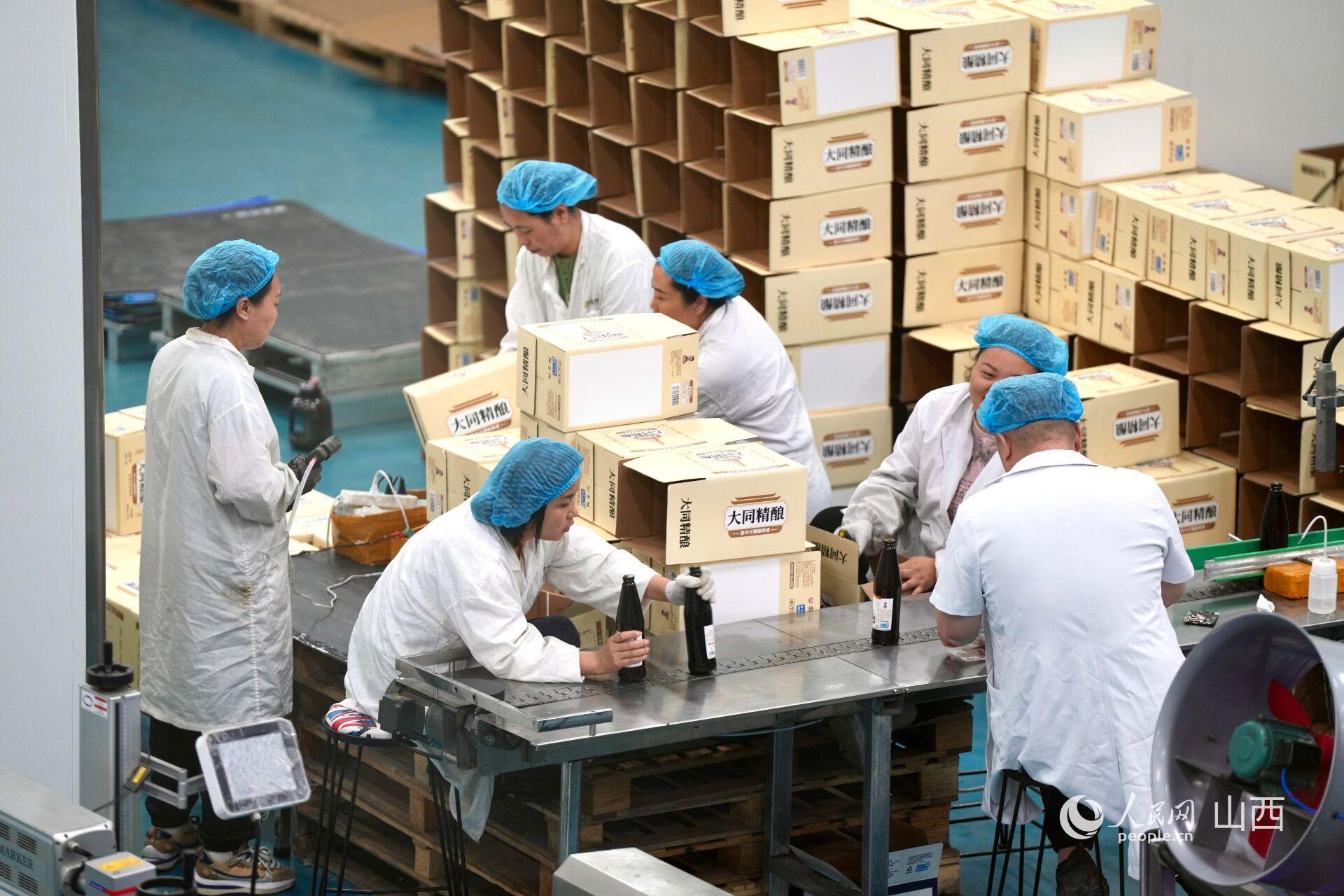 大同三利集团生产车间内，工人正在分装黄花啤酒。人民网 卢鹏宇摄