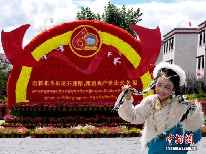 8月19日,随着西藏自治区成立60周年庆祝活动临近,拉萨氛围浓。拉萨街头,处处是张灯结彩的盛景,洋溢着一派祥和与欢腾的氛围。图为游客在拉萨大昭寺广场上的大庆宣传标语前留念。<a target='_blank' href='/'>中新社</a>记者 李林 摄