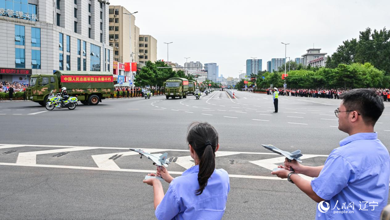 航空工业沈飞的青年技术人员拿着受阅战机的模型迎接烈士遗骸。航空工业沈飞供图