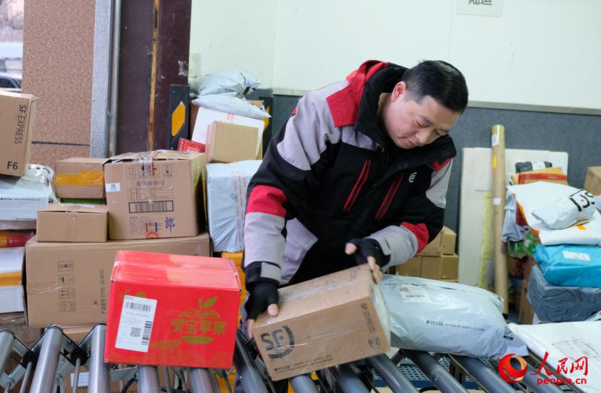春节前包裹量攀升，任秀林认真分拣、细致查验，守护年货安全。人民网记者 常力元摄