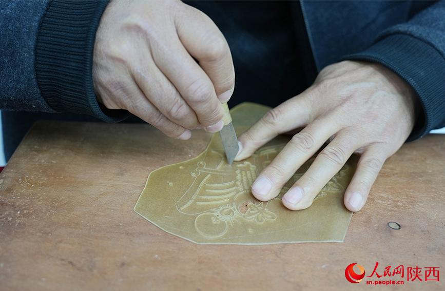 陈义文正在进行雕刻皮影。人民网记者 孙挺摄