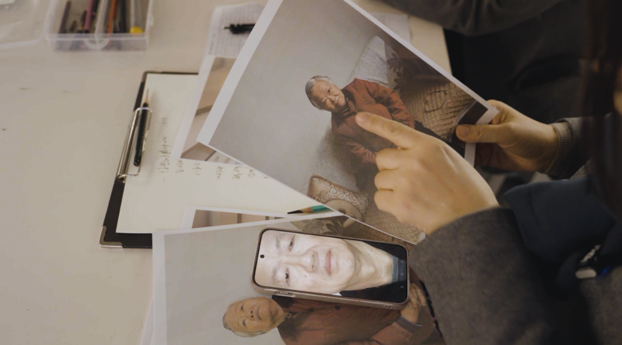 专业老师们探讨烈士亲属容貌特点。人民网记者 邱宇哲摄