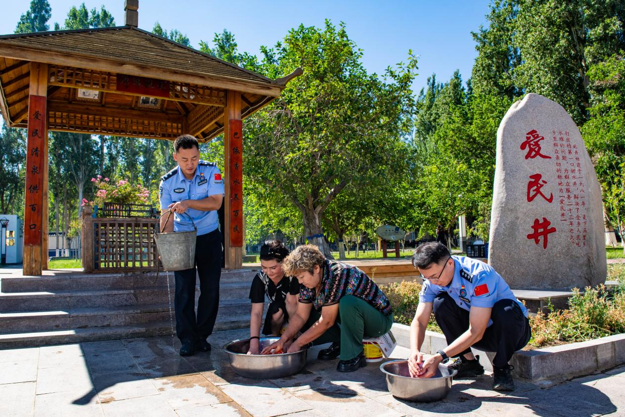 下马崖边境派出所民警与辖区群众在“爱民井”旁,一同打水洗菜、架锅做饭。下马崖边境派出所供图