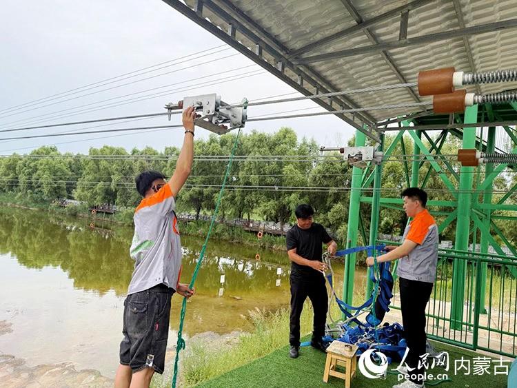 张振东（右）和发小一起调试设备。人民网记者 孟佳澍摄